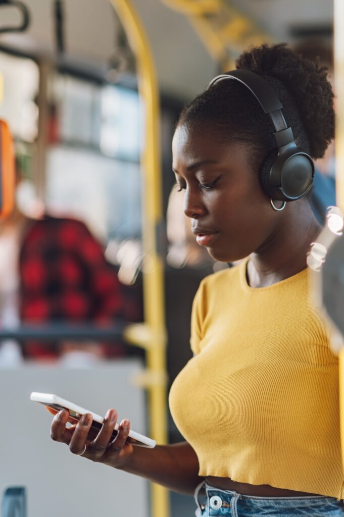 African american woman riding a bus and using a smartphone